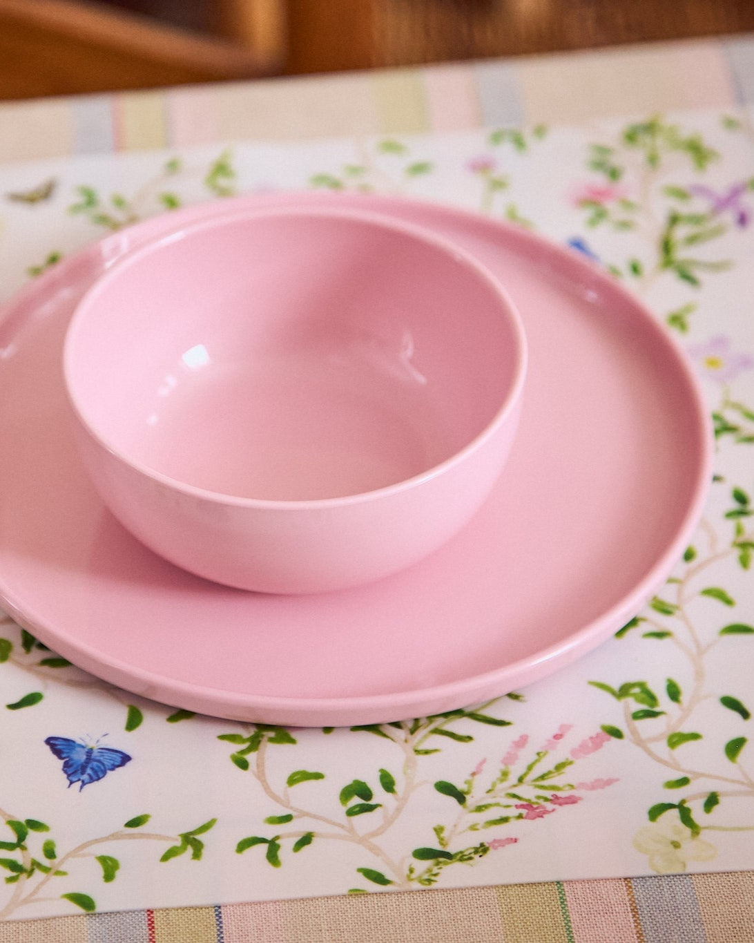 Pink plate and bowl set sitting on a floral placemat
