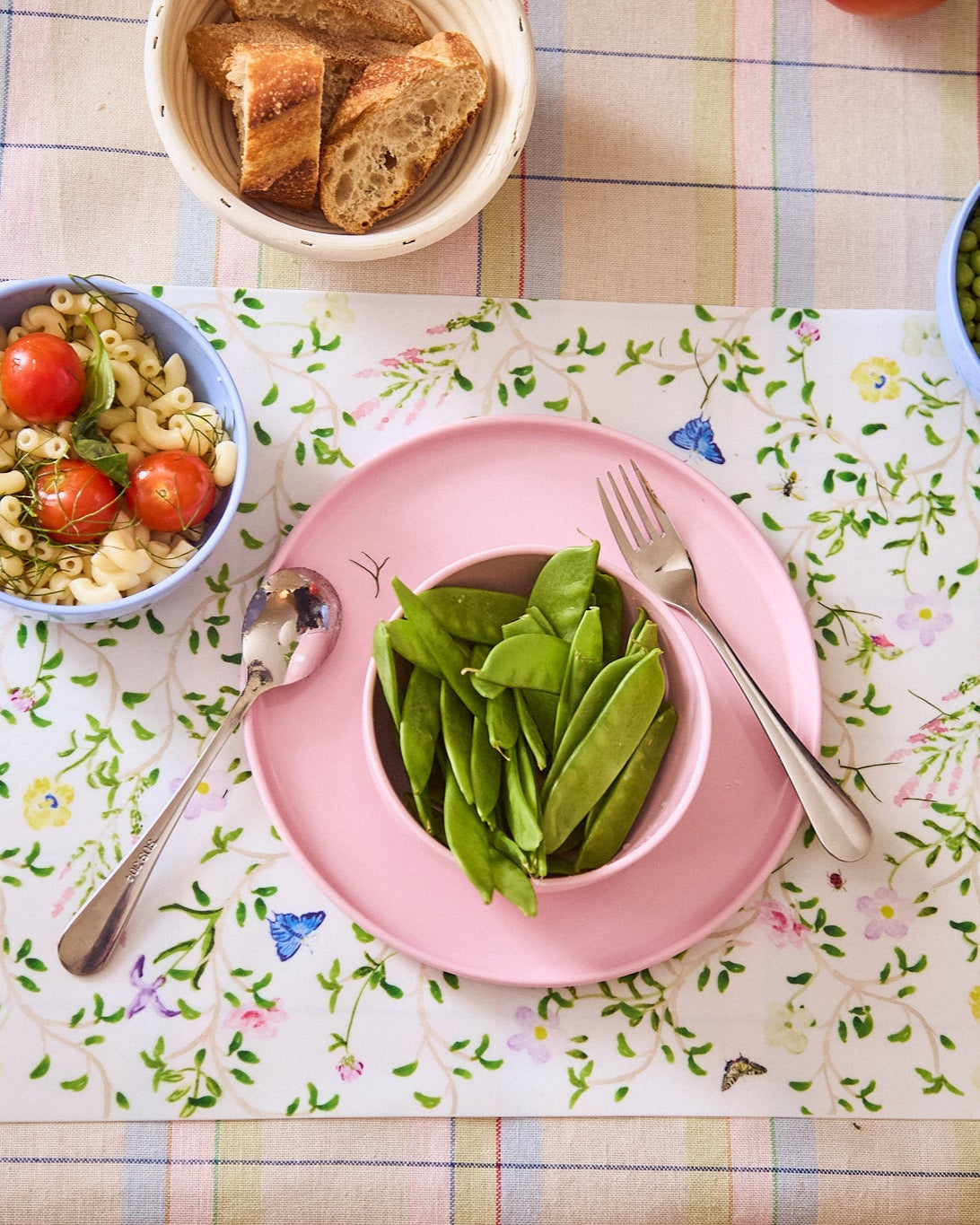 fresh spring peas tomatoes and pasta on recette plates with a spoon and fork