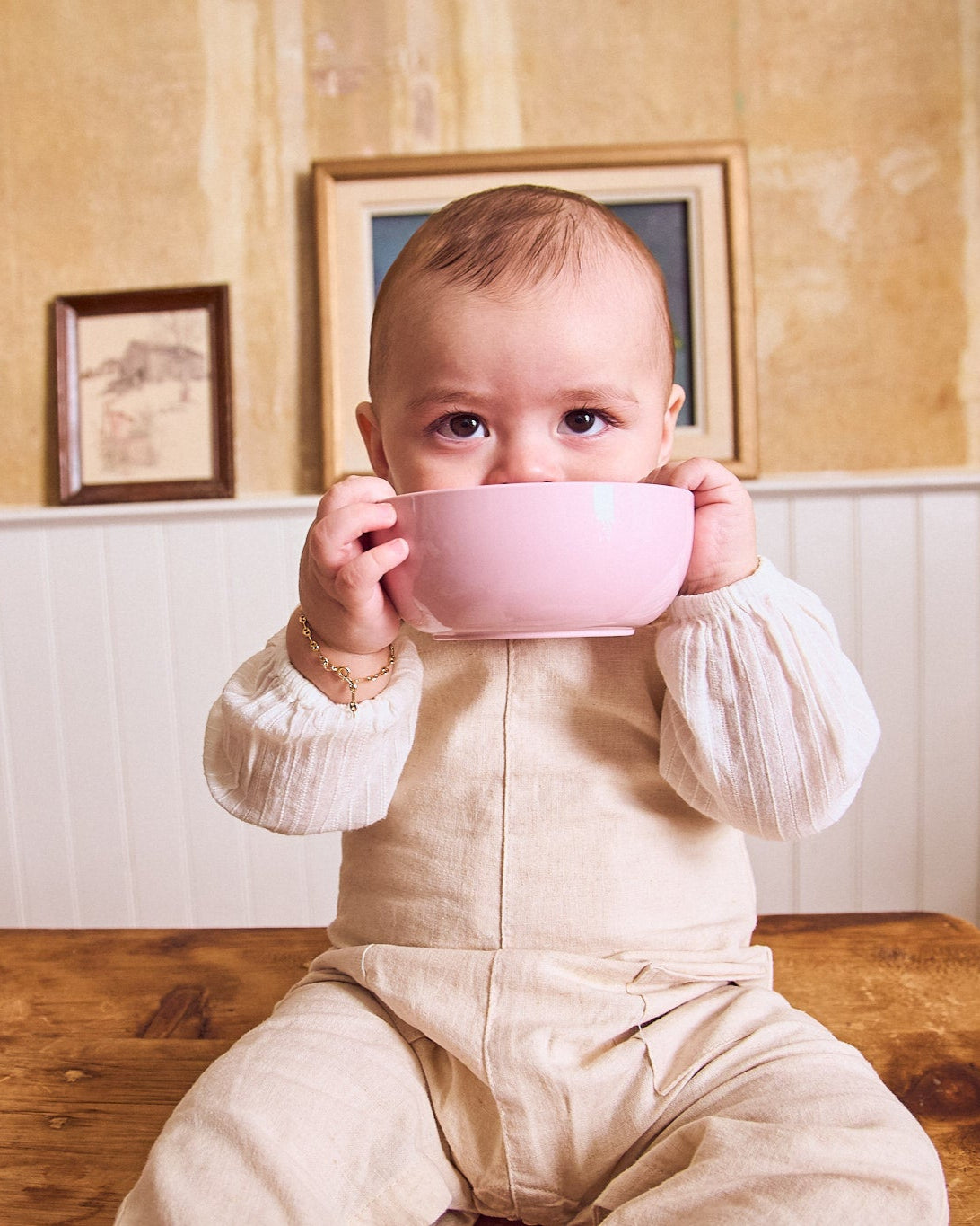 Baby eating from a pastel pink non-toxic bowl