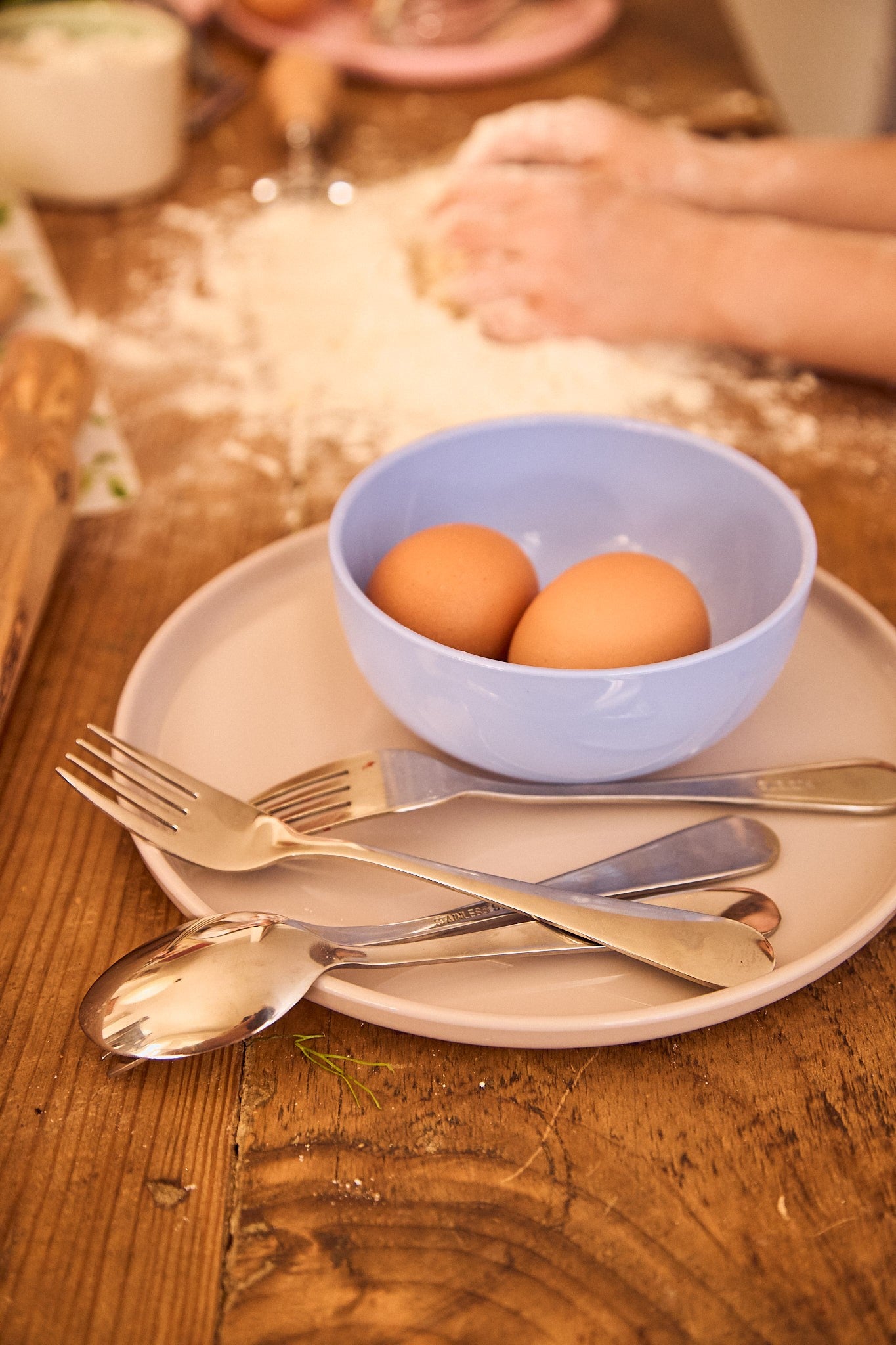 Pastel blue non-toxic bowl on a warm wooden table with eggs inside