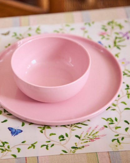 Pink plate and bowl set sitting on a floral placemat